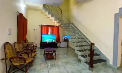 a room with a staircase with chairs and a television at The Cove, ' the silent Symphony ' in Parassinikadavu