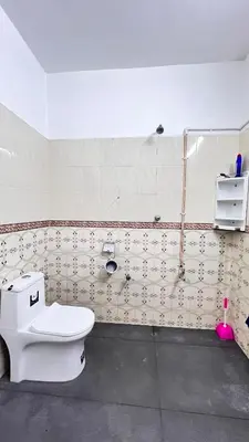 a bathroom with a toilet and a shower at Royal Rivera Holiday Home in Kalpetta