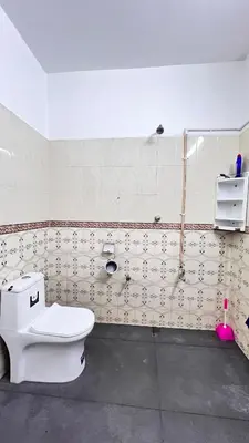 a bathroom with a toilet and a shower at Royal Rivera Holiday Home in Kalpetta