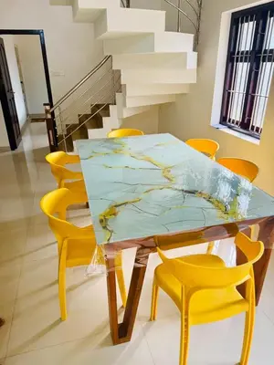 a dining table with yellow chairs around it at Ocean pearl homestay-pariyaapuram