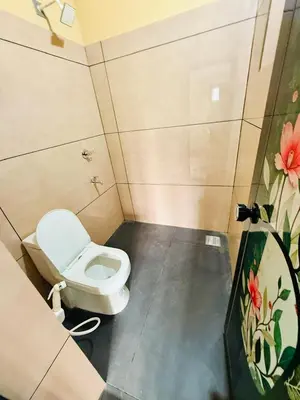 a small bathroom with a toilet in a stall at Ocean pearl homestay-pariyaapuram