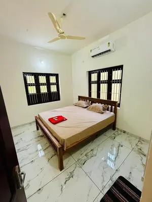 a bedroom with a bed and a ceiling fan at Ocean pearl homestay-pariyaapuram