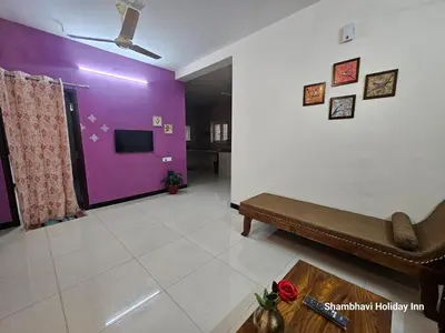 a living room with a couch and a purple wall at SHI's Krishna 2BHK Villa Furnished Cozy Stay in Coimbatore