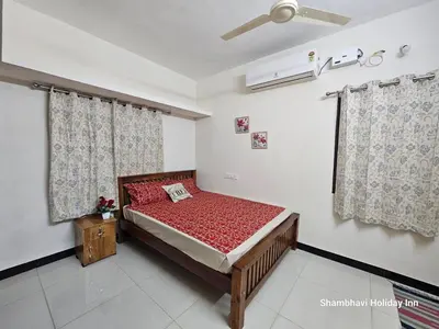 a bedroom with a bed with red sheets and curtains at SHI's Krishna 2BHK Villa Furnished Cozy Stay in Coimbatore