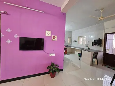 a living room with a large purple wall at SHI's Krishna 2BHK Villa Furnished Cozy Stay in Coimbatore