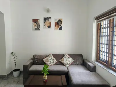a living room with a couch and a table at Riverfront Villa in Kochi in Kodungallūr