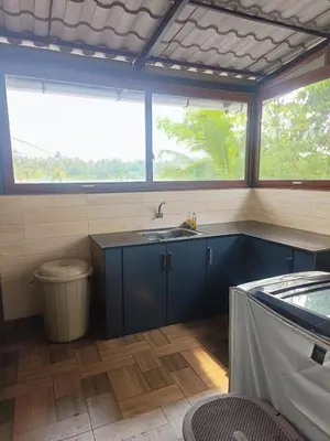 a kitchen with a sink and two windows at Riverfront Villa in Kochi in Kodungallūr