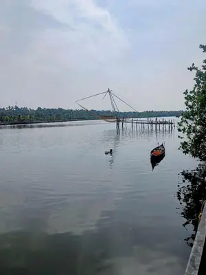a boat in the water next to a bridge at Riverfront Villa in Kochi in Kodungallūr