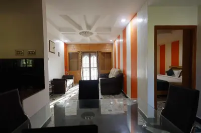 a living room with a glass table and a couch at Cozy Ooty Resort in Ooty