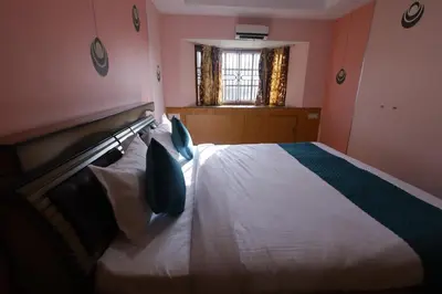 a bedroom with a large white bed with blue pillows at Cozy Ooty Resort in Ooty