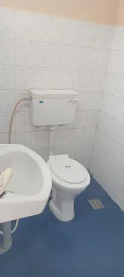 a bathroom with a white toilet and a sink at Sithara Guest House in Palakkad