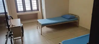 a small hospital room with a blue bed in it at Sithara Guest House in Palakkad
