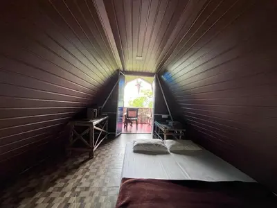 a bedroom with a bed in a room with a window at Hornbill Paradise, Munnar in Viripara