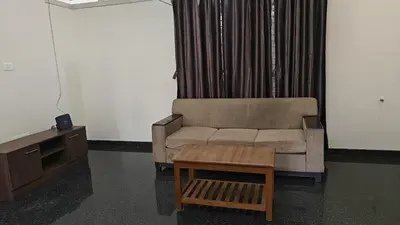 a living room with a couch and a table at Gamani in Mysore