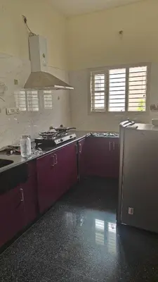 a kitchen with purple cabinets and a stove in it at Gamani in Mysore