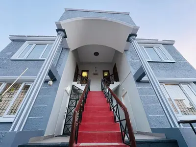 a stairway leading up to a building with red stairs at Little Home By D2V in Ooty