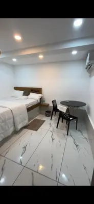 a bedroom with a bed and a table and chairs at Ichakkans beach resort in Irimbranallūr