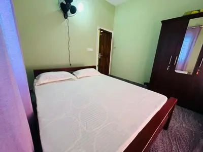 a small bedroom with a white bed in it at AGNEYA Holiday Home in Wayanad