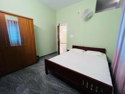 a bedroom with a bed and a closet and a door at AGNEYA Holiday Home in Wayanad