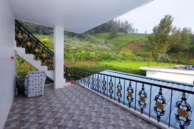 a balcony with a staircase and a view of a hill at Hillside haven ooty in Ooty