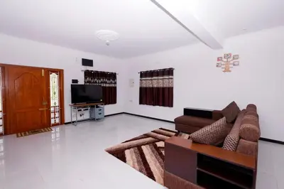a living room with a couch and a tv at Hillside haven ooty in Ooty
