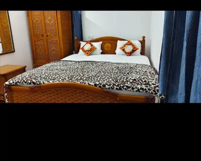 a bedroom with a bed with a wooden head board at Hilarious Garden Ooty in Ooty