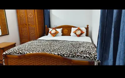 a bedroom with a bed with a black and white comforter at Hilarious Garden Ooty in Ooty