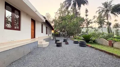 a building with a row of stools outside of it at Wildora Junglevilla Wayanad in Chekadi