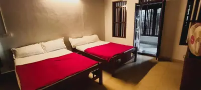 two beds sitting in a room with a window at Wildora Junglevilla Wayanad in Chekadi