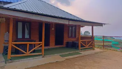 a small wooden house with a metal roof at Mud bees resort in Kanthalloor