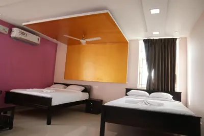 two beds in a room with a large window at Luxury Stays in Coimbatore