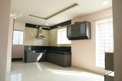 a large kitchen with black counters and appliances at Luxury Stays in Coimbatore