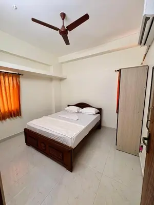 a bedroom with a bed with a ceiling fan at Nexusliving in Coimbatore