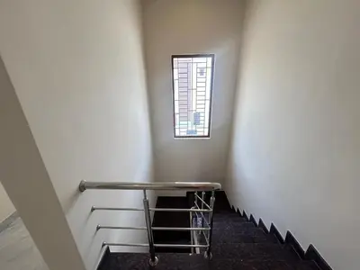 a small staircase with a table in a room with a window at House of KRM - Nilgiris Outlook in Kāramadai