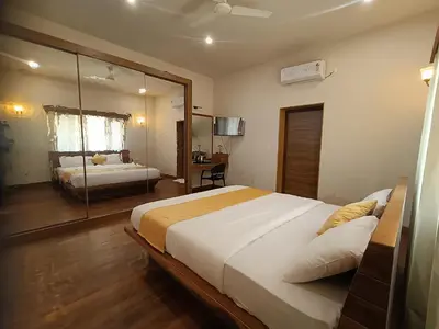 a bedroom with a large bed and a mirror at Sky16cafe in Kushālnagar
