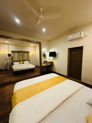 a bedroom with a large bed and a mirror at Sky16cafe in Kushālnagar
