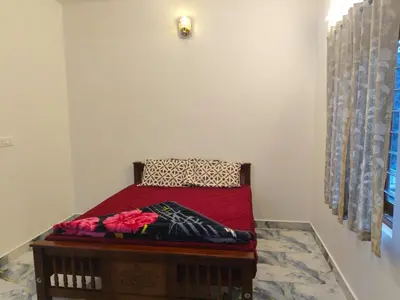 a small bed in a corner of a room at Nakshatra Home Stay in Vattavada