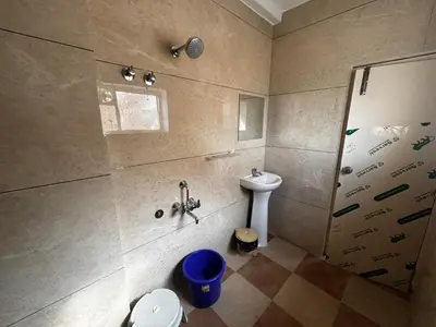a bathroom with a shower and a toilet and a sink at Surabhi Comforts Inn in Mysore