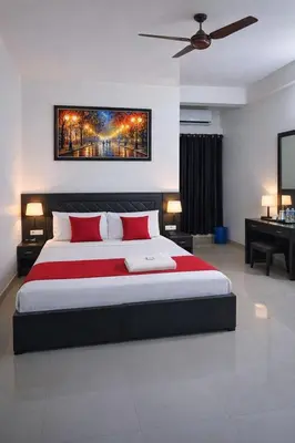 a bedroom with a large bed with red pillows at Saravana tourist home in Kozhikode