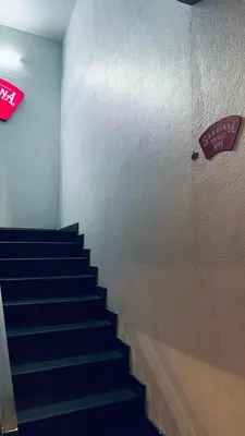 a staircase in a building with a sign on the wall at Saravana tourist home in Kozhikode