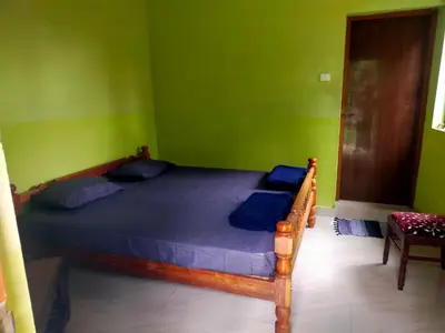 a bedroom with a bed in a green room at Silver Rock Cottage Valparai in Vālpārai