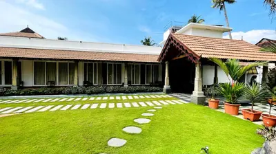 a house with a green lawn in front of it at Breakwater Palace in Cochin