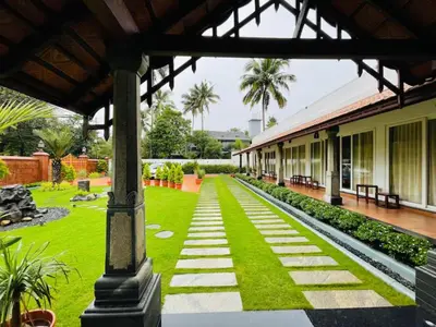 a courtyard of a building with grass and a pathway at Breakwater Palace in Cochin