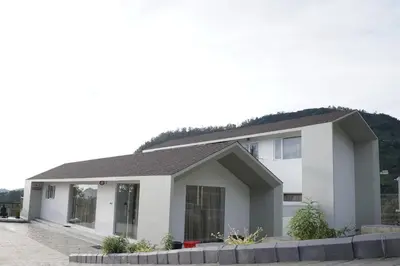 a white house with a gray roof at Jacaranda Home Stay in Kotagiri