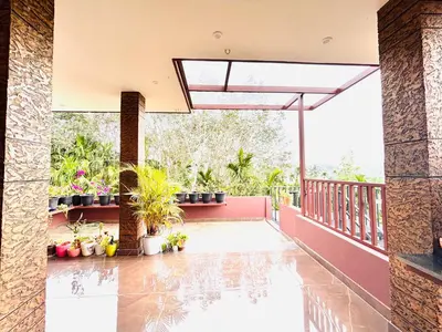 a balcony of a house with potted plants at Tanis serenity in Meenangadi