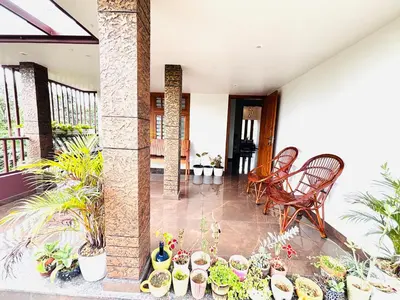a porch with plants and chairs and a bunch of potted plants at Tanis serenity in Meenangadi