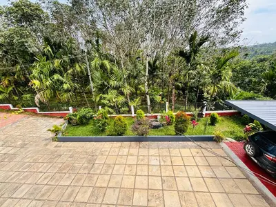 a driveway with a car parked in a yard at Tanis serenity in Meenangadi