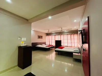 a room with two beds and a window at Chandragiri INN in Kalpetta