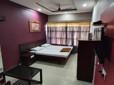 a small bedroom with a bed and a window at Chandragiri INN in Kalpetta