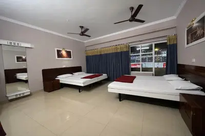 a bedroom with two beds and a window at Chandragiri INN in Kalpetta